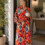 Woman wearing red, orange, and teal ikat print satin-finish kimono robe, handcrafted in Rajasthan BUW516